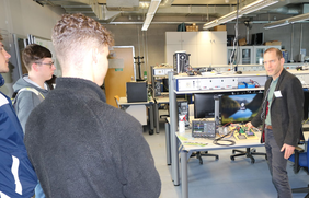 Professor zeigt Interessenten Geräte aus einem Labor