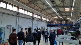 : The participants of the excursion visit a workshop hall.