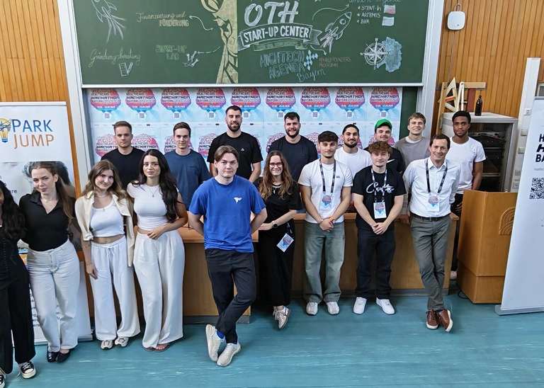 Group photo of students and a professor in a lecture hall