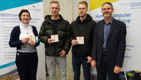 Prof. Dr. Andreas Riener (right), two of the winners (middle), Martina Schuß (left) handing over the vouchers. Source: THI