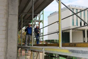 Es war vor allem auch ihr Fest: Die Handwerkerinnen und Handwerker haben entscheidend zum Gelingen des Projekts beigetragen (Foto: THI). Bild von zwei Männern auf dem gerüst des Digitalbaus beim Richtspruch
