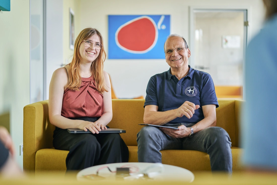 Zwei Promovierende diskutieren über technisches Equipment im Labor.