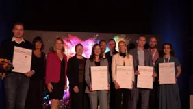 Gruppenbild der elf Ausgezeichneten mit Urkunden der FGF