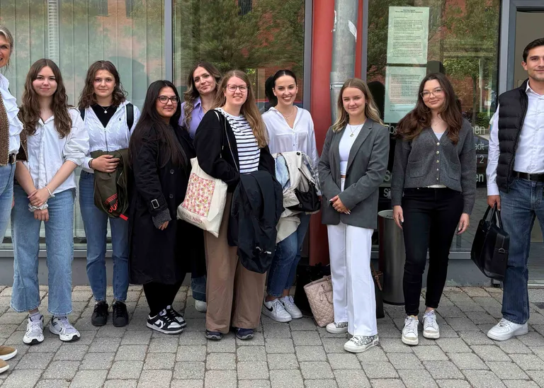 a group of ten people smiles at the camera