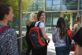 Imagebild zu Master-Talks, Gruppe von Studierenden mit THI-Rucksack auf dem Weg zu einer Vorlesung