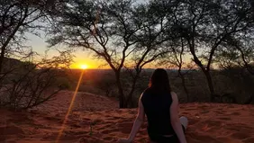 Studentin sitzt im Sonnenuntergang in der afrikanischen Wüste