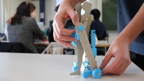 [Translate to English:] Ein Studierender zeigt das 3D-Modell der Mobilitätserweiterung für Kinder