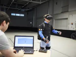 Person mit Bewegungssensortechnik am Körper, Bildschirm mit Simulation