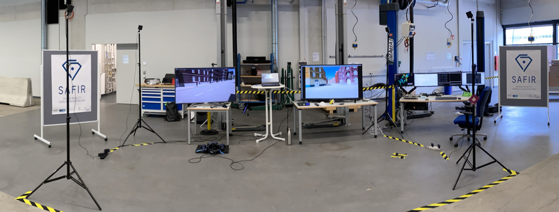Abbildung eines Versuchsaufbaus mit zwei Bildschirmen und SAFIR Postern links und rechts