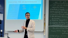 A man in front of a presentation.