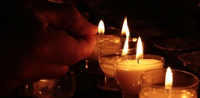Die Hochschulfamilie ist in Gedanken bei den Angehörigen der Vermissten (Symbolfoto: Pixabay). Symbolbild, das brennende Teelichter darstellt, sowie eine Hand mit einem brennenden Streichholz