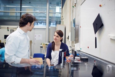 Two doctoral students discuss technical equipment in the laboratory