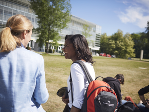 Professorin mit Studentin auf Campuswiese