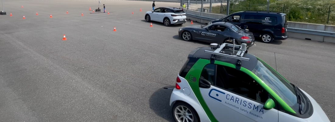 Abbildung eines Versuchsaufbaus mit autonom fahrenden Fahrzeugen auf der Teststrecke