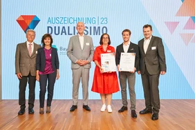 Happy about the success: Award winner Jan Wellhöfer (2nd from right) with his parents (l.), Elke Heimgärtner-Geier (3rd from right), management of Collomix GmbH, THI president Walter Schober (3rd from left) and THI professor Andreas Rattke (r.). (Photo: BayZiel-hochschule dual) 