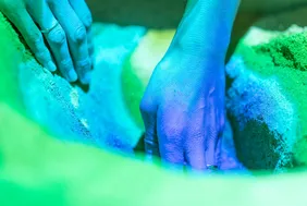 Händepaar, das im Sand gräbt