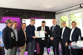 StM Markus Blume überreicht den beteiligten Partnern die Urkunde zum Technologietransferzentrum "Unbemannte Flugsysteme" in Manching.