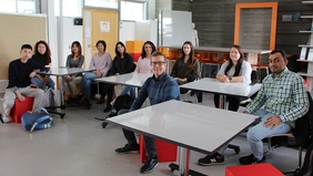 students sitting in a row with Prof. Dr. Martin Petroll in the Retail Lab of THI Business School. 