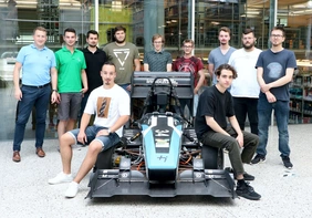 Ten students with Professor Diel and the electric racing car