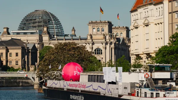 Bild mit Blick auf das schwimmende Science Center der MS-Wissenschaft auf der Spree, im Hintergrund das Reichstagsgebäude 