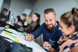 Ein Student und eine Studentin sitzen gemeinsam über Lernunterlagen 