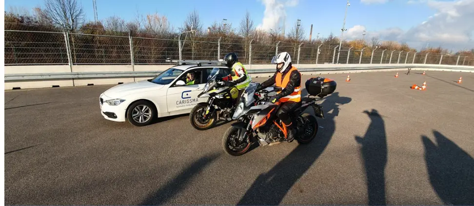 Picture of two motorbikes and the CARISSMA test vehicle on the test track