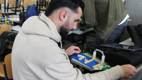 A male person works with Lego bricks