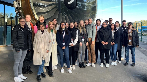 A group of students in front of a giant turbine.