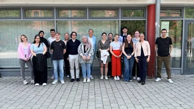 A group of 17 people in front of the entrance to the labor court.