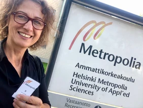 Prof. Ingrid Stahl In front of a sign of Metropolia UAS in Helsinki, Finland