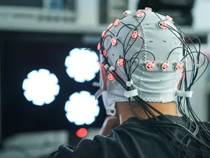 Ein menschlicher Kopf ist dicht mit elektronischen Kabeln verbunden