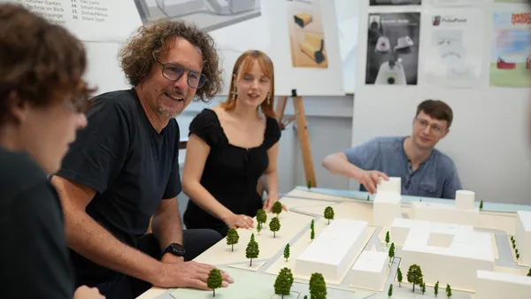 Personen, die um ein Modell des THI Campus sitzen