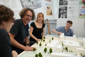 Personen, die um ein Modell des THI Campus sitzen