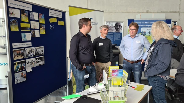 Professors Jarschel, Gold and Frey talking to a teacher at the Faculty of Computer Science´s stand