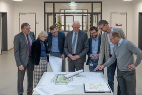 Lord Mayor Dr Bernhard Gmehling, Dean Professor Jana Bochert, Chancellor Christian Müller, THI President Professor Walter Schober, Site Manager Stefan Hoiczyk, Head of the State Building Construction Office Thomas Sendtner and Vice Dean Professor Oliver Blask (from left to right) are visibly impressed by the highly attractive designs (Photo: THI).