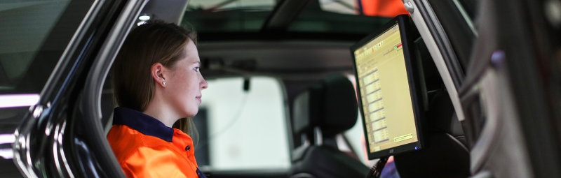 Abbildung: Eine Technikerin liest die Daten im Fahrzeug aus.