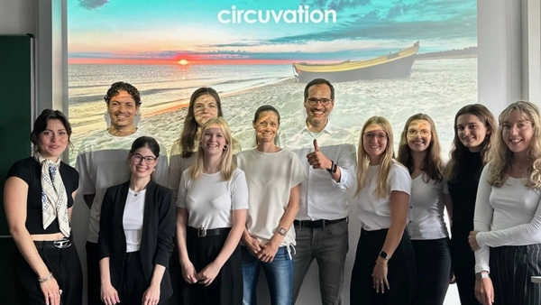 : A group of eleven people is smiling at the camera