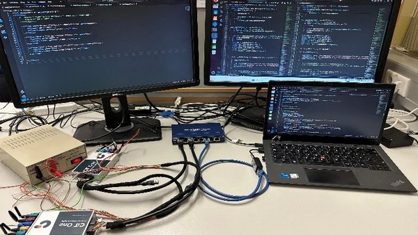 Abbildung eines Laptops und zwei Monitore im Hintergrund