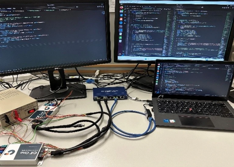 Abbildung eines Laptops und zwei Monitore im Hintergrund