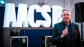 A man in a suit smiles at the camera 