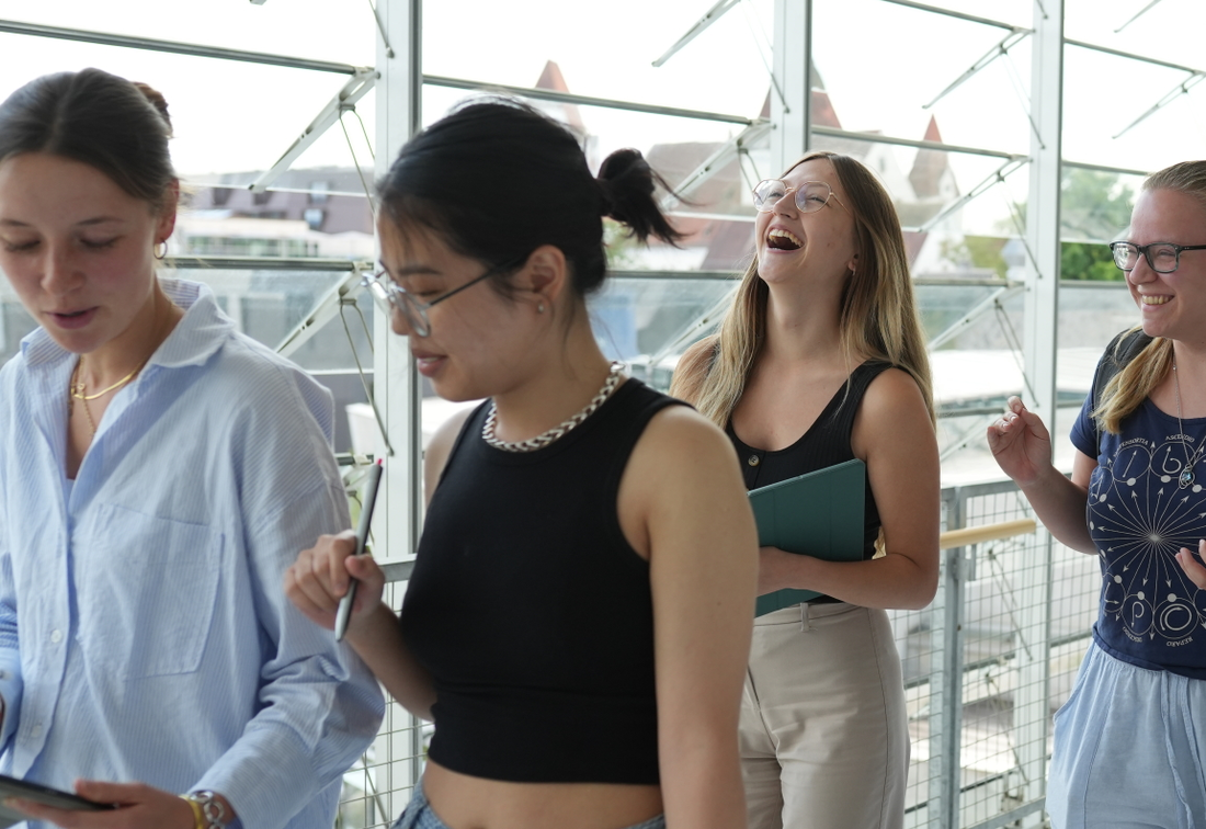 5 Studierende gehen in einem Gang der THI und sind glücklich