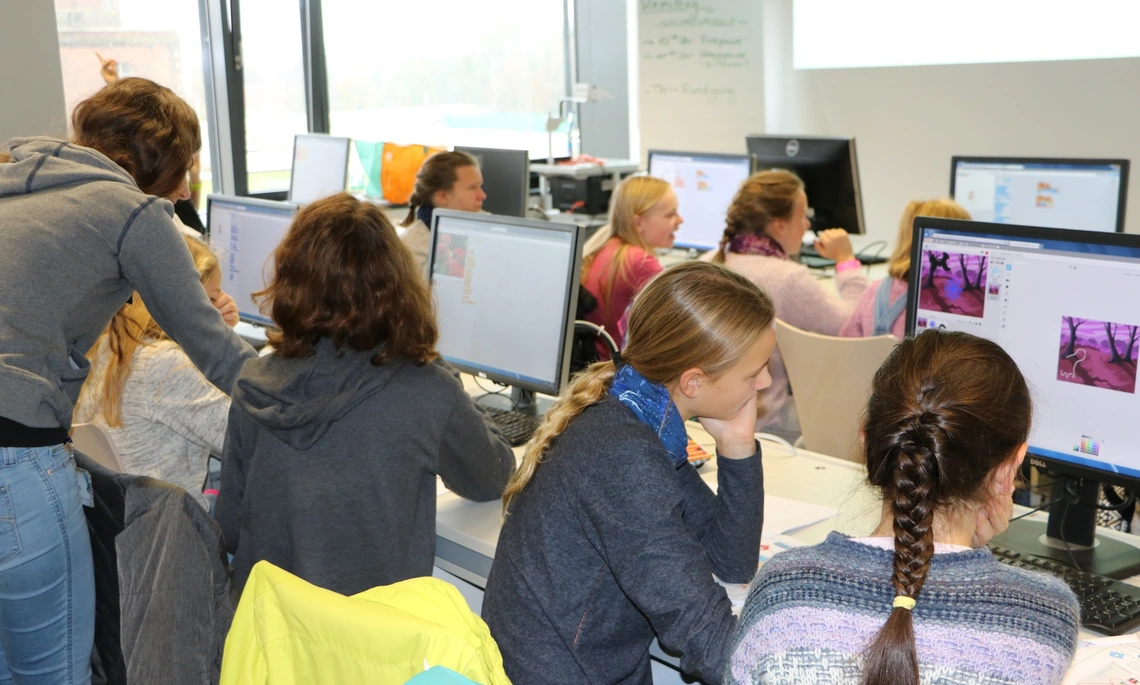 Schoolgirls sitting in front of computer screens