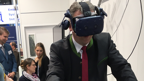 Secretary of State Roland Weigert tries out THI's virtual bicycle helmet 