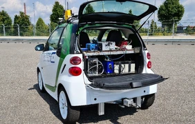 Picture of a smart car with open boot in which the test devices are visible.