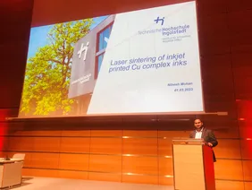 Bild von Präsentation zum AGE-Projekt auf der Leinwand und Sprecher