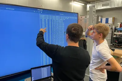 Zwei Personen vor Großbildschirm mit Testdaten