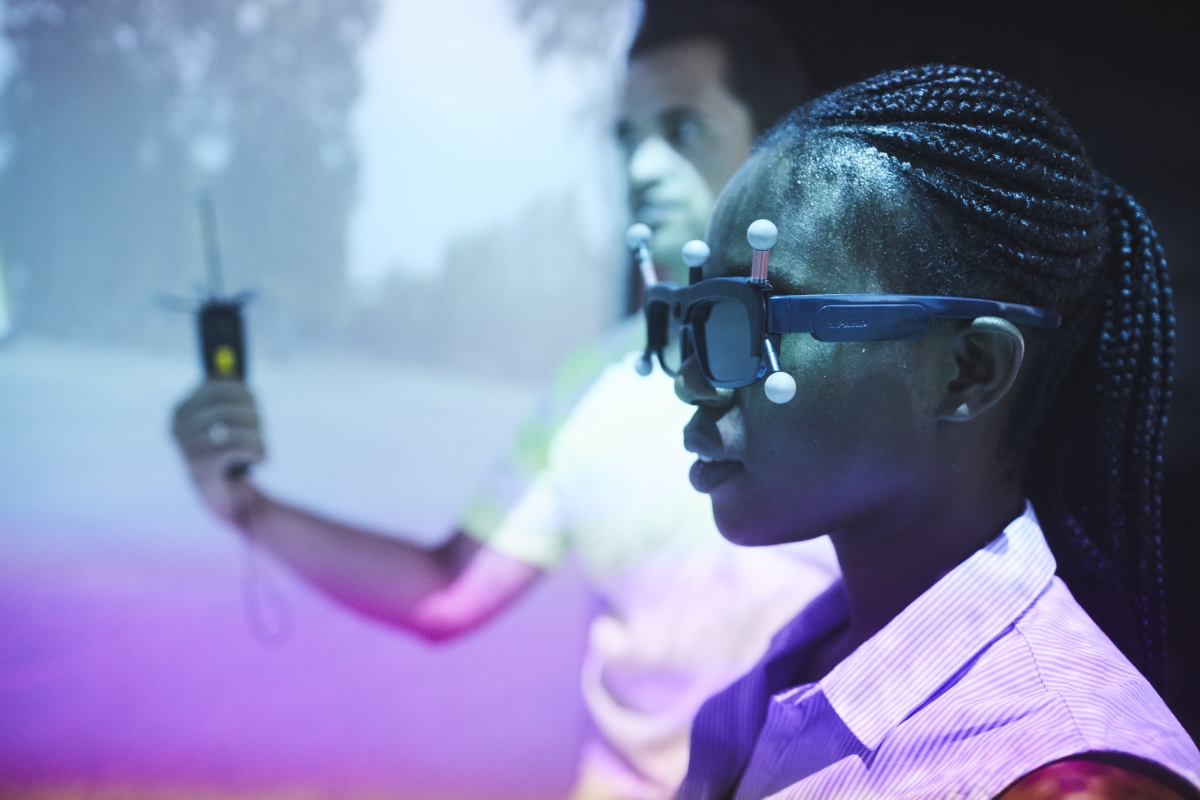 Man sieht eine junge Frau, die eine VR-Brille trägt, an der zusätzlich Sensoren befestigt sind.